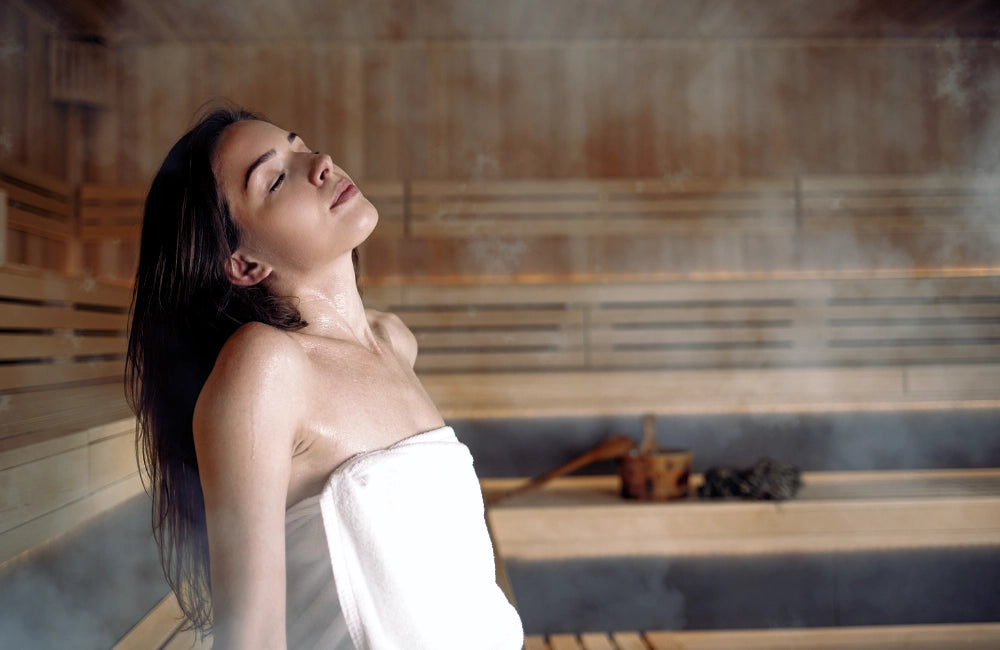 Junge Frau entspannt und atmet tief in der Sauna
