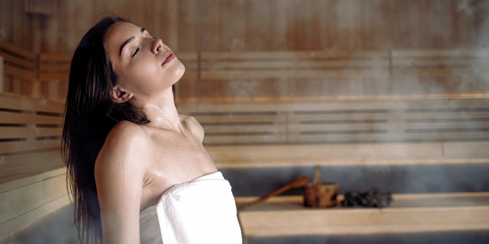 Frau atmet tief durch und entspannt in der Sauna